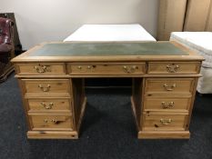 A pine twin pedestal desk with inset green leather panel