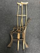 A pair of vintage wooden crutches together with a set of cast iron bench ends