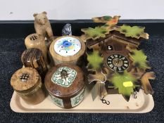 A tray containing a cuckoo clock with pendulum and weights, wooden lidded jars,