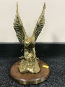 A brass American Bald Eagle ornament on wooden base