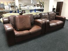 A pair of brown leather two-seater settees with matching footstool