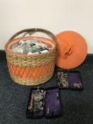 A wicker sewing basket and two Singer tins of sewing machine accessories