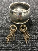 A pair of gold earrings and a silver napkin ring