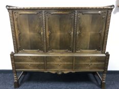 A twentieth century oak triple door sideboard fitted with six drawers