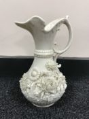 A Belleek jug with floral decoration CONDITION REPORT: Some minor chips to the