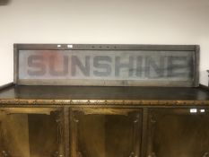 A metal Sunshine advertising sign