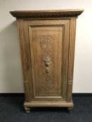 A late 19th century oak carved panelled side cabinet,