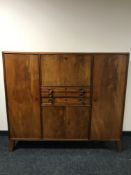 A mid 20th century mahogany sideboard, fitted with cutlery drawers and panel doors,