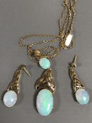 A 15ct gold opal pendant on chain together with the matching pair of earrings, 15.4g gross.