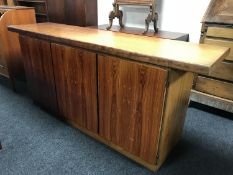 A Danish rosewood low sideboard by Skovby, with fitted interior and enclosed by three panel doors,