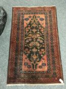 A Persian Baluchi rug, on rust ground, 87 cm x 142 cm.