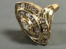 A 14ct gold diamond cluster ring, centering on a marquise cut diamond,