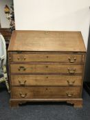 A 19th century oak bureau, on bracket feet,