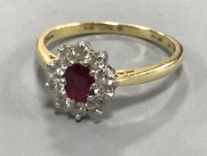 An 18ct gold ruby and diamond cluster ring, size N/O.