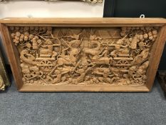 An early 20th century carved Eastern panel, profusely carved with figures in battle,
