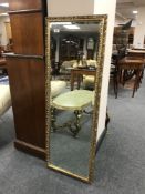 A gilt framed rectangular mirror with bevelled glass, 44.5 cm x 126.5 cm.