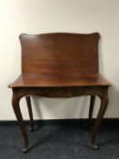 An inlaid mahogany turn over top tea table, on cabriole legs,