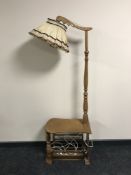 A continental oak multi function standard lamp with magazine rack below,
