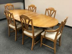 A light elm extending oval dining table, with leaf and six matching chairs, fully extended 203 cm.