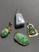 Three mottled jade yellow metal mounted pendants, together with one other similar.