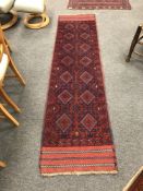 A Persian Meshwani carpet runner on red ground,