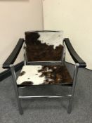 A late 20th century tubular steel and black leather sling chair, upholstered in animal hide,