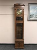 A continental oak longcase regulator clock with brass dial