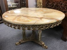 A good quality variegated onyx coffee table, on brass tri form base, with onyx pillars, width 75 cm.
