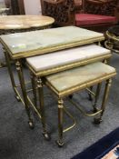A nest of three gilt brass and onyx tables, width 51 cm.