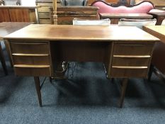 A mid 20th century teak pedestal desk, fitted with six drawers, on cylindrical legs,