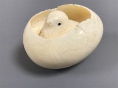 An early twentieth century carved ivory chick in shell, length 5 cm.