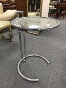 A mid 20th century tubular steel adjustable glass topped circular coffee table, diameter 51 cm.