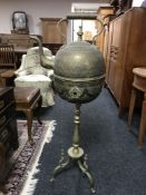 An antique Eastern brass kettle on stand,
