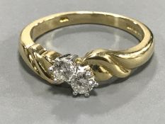 An 18ct gold two-stone diamond ring, approximately 0.2ct, size M/N.