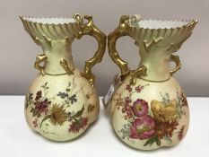 A near pair of Royal Worcester blush ivory gilded ewers,