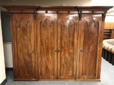 A Victorian Gothic revival four door wardrobe, with arched Gothic detail,