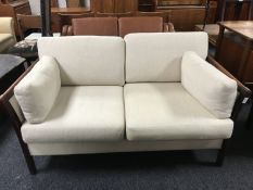 A continental two seater settee upholstered in oatmeal fabric by Friis,