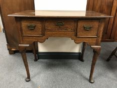A George III oak low boy fitted with three drawers on pad feet, width 82.