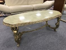 A good quality onyx coffee table mounted on brass trestle type base supported by maidens,