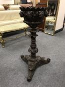 A Regency carved walnut jardiniere on stand, the bowl profusely carved with leaf and grape design,