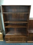 A mid 20th century rosewood bookcase, fitted with two drawers below,