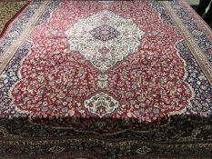 An Isfahan design carpet on red ground 330 cm x 240 cm.