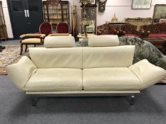 A contemporary cream leather adjustable two seater settee, on polished steel supports, by De Sede,