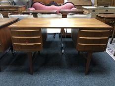 A mid 20th century teak pedestal desk, fitted with six drawers, on tapered legs,