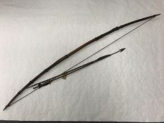 A 19th century Zulu long bow and two arrows. (3) CONDITION REPORT: Bow length 161.