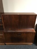 A mid 20th century rosewood fall front cabinet, fitted with double doors below,
