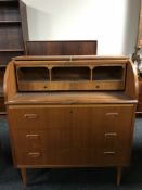 A mid 20th century teak roll topped bureau, fitted with three drawers,