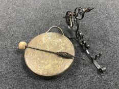 A brass gong with beater, on decorative metal bracket.