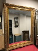 A contemporary gilt overmantel mirror in ornate frame,