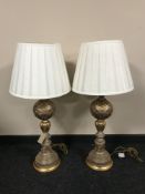 A pair of silver and gilt table lamps with shades